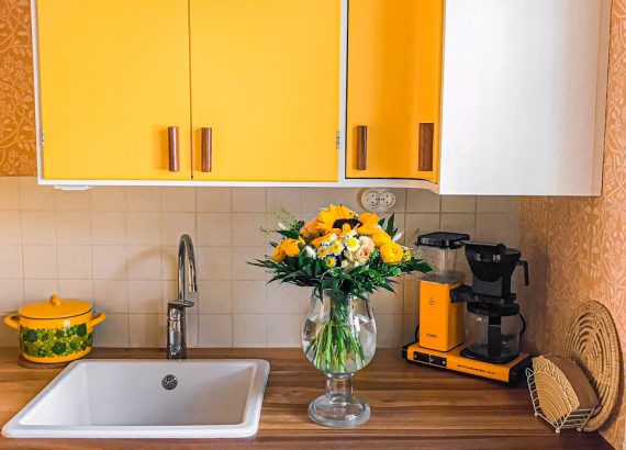 Keltainen keittiö ja kukkakimppu
